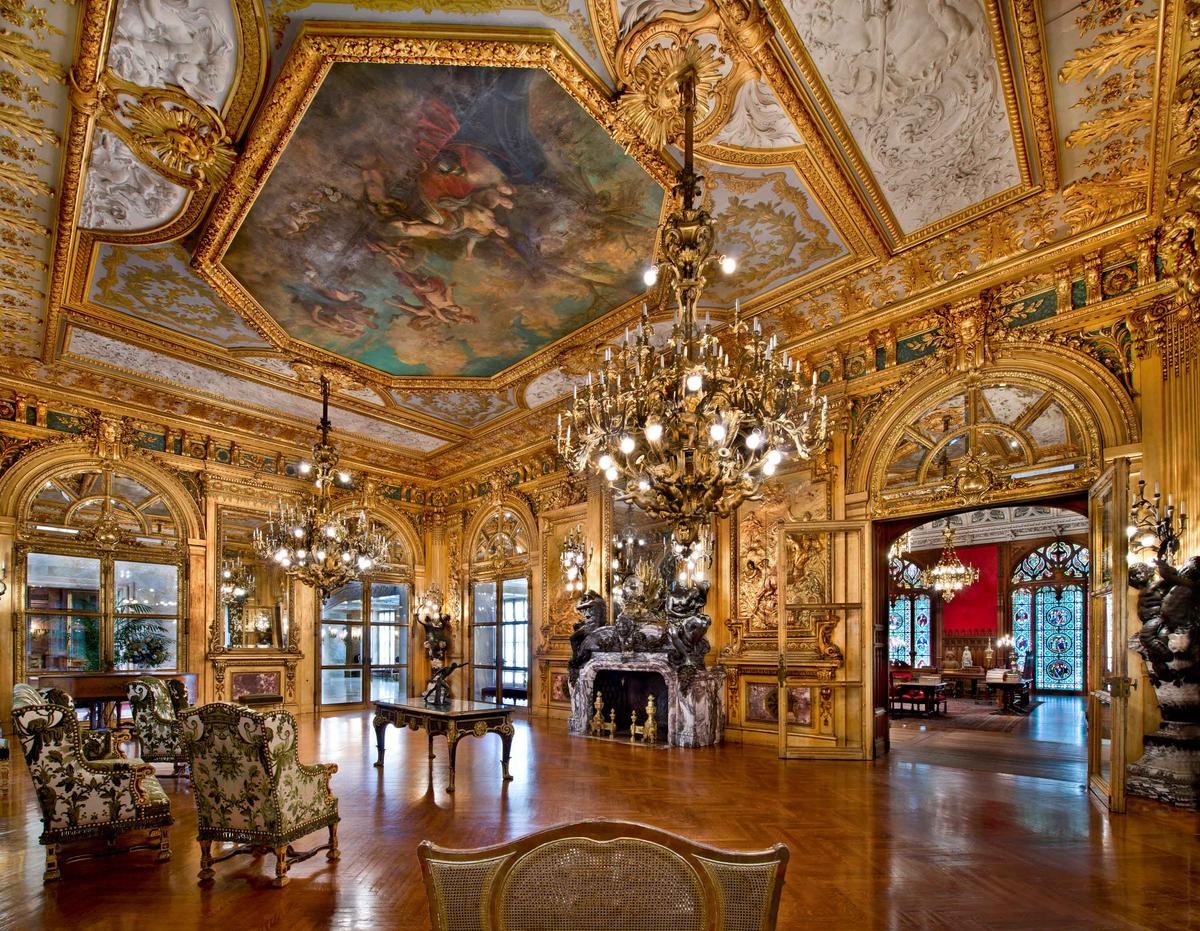 The Grand Salon (also called the Gold Room) served as a ballroom and was recognized as “one of the grandest ballrooms ever to be built in Newport.” The Gold Room features gold gilt paneling over wooden walls carved to represent scenes from classical mythology, inspired by the Apollo Gallery at the Louvre. (Courtesy of The Preservation Society of Newport County)