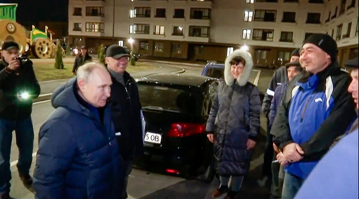 Russian President Vladimir Putin talks with local residents during his visit to Mariupol in Russian-controlled Donetsk region, in a still from video released on March 19, 2023. (Russian TV Pool via AP)
