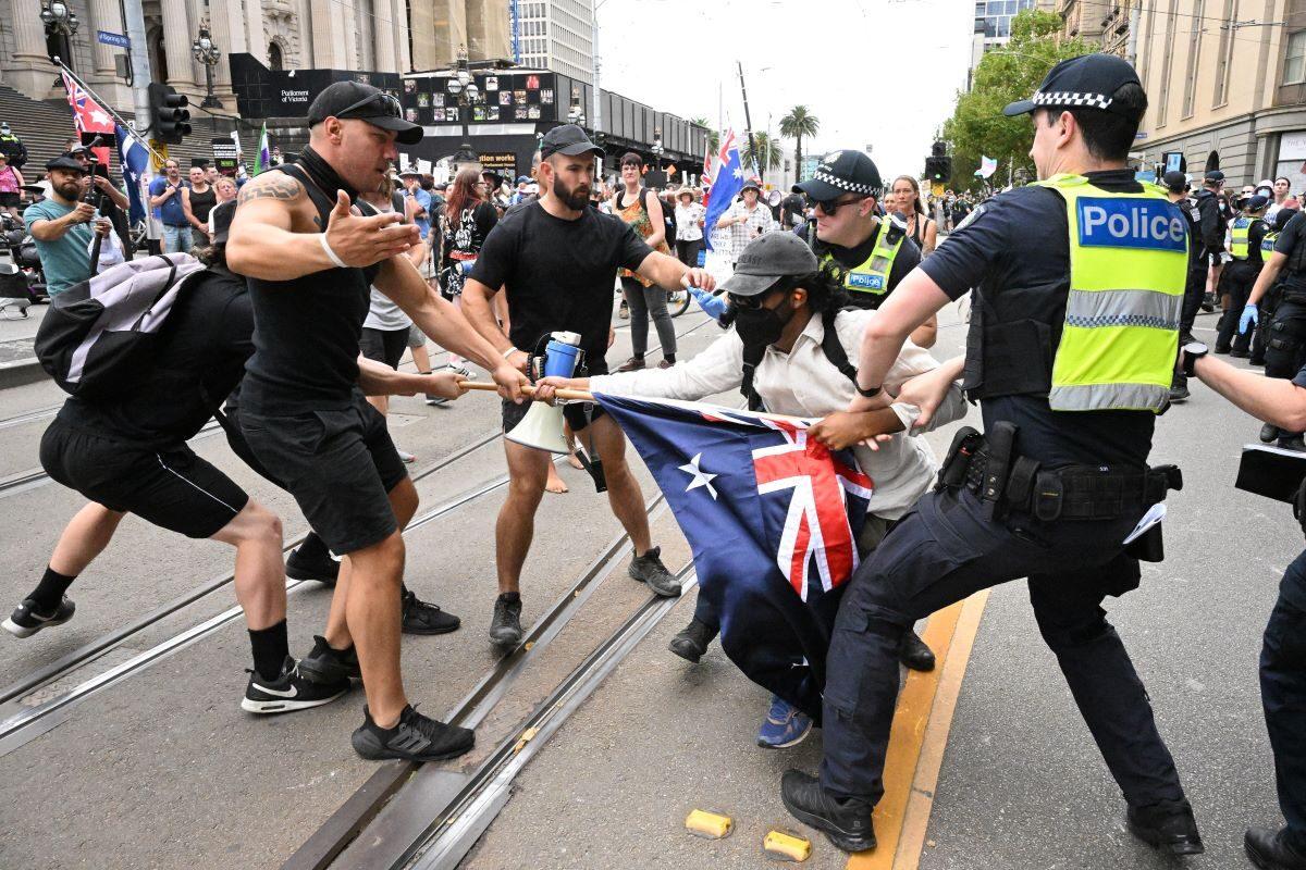 Police remove a protester during a transgender rights rally, involving opposing neo-Nazi protesters, outside Parliament House in Melbourne, Australia, on March 18, 2023. (James Ross/AAP Image)