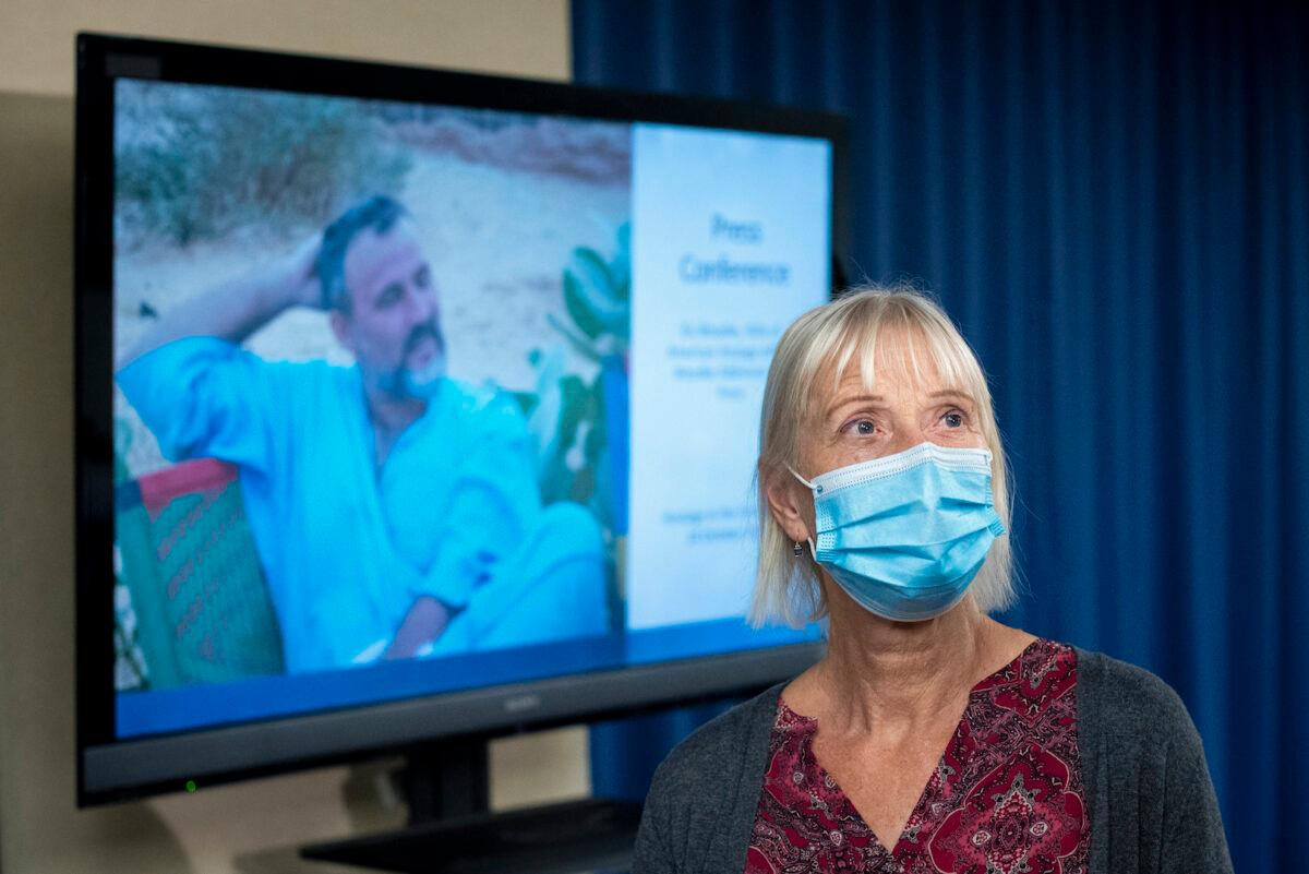 Els Woodke speaks about the 2016 kidnapping of her husband, Jeffrey Woodke, that occurred in West Africa during a news conference in Washington on Nov. 17, 2021. A photo of Jeffrey Woodke is seen on a video monitor in the background. (Cliff Owen/AP Photo)