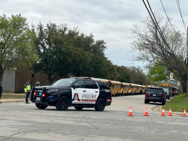 Students at Lamar High School in Arlington, Texas, were taken by bus to a reunification center after a shooting occurred on campus on March 20, 2023. (Jana Pruet/The Epoch Times)