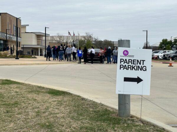Parents line up to pick up their children who were taken to a parent reunification center after a shooter killed one student and injured another at Lamar High School in Arlington, Texas, on March 20, 2023. (Jana Pruet/The Epoch Times)