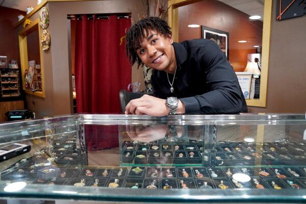Mikah Snowden, a sales representative at Galina Fine Jewelers in Cottonwood, Ariz., works behind the showcase on March 20, 2023. (Allan Stein/The Epoch Times)