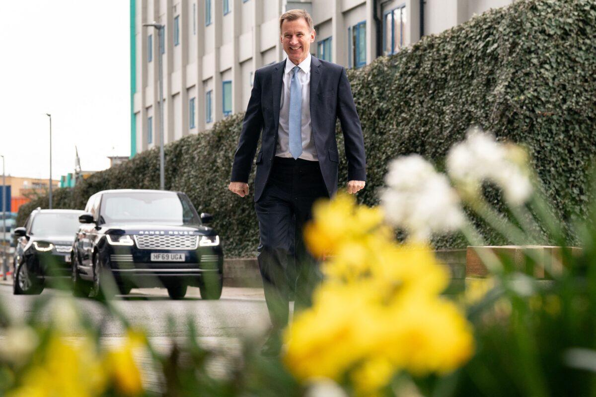 Britain's Chancellor of the Exchequer Jeremy Hunt walks through spring flowers as he arrives to meet children and staff at Busy Bees Battersea Nursery in south London, on March 15, 2023, after delivering his Budget earlier in the day. (Stefan Rousseau/POOL/AFP via Getty Images)