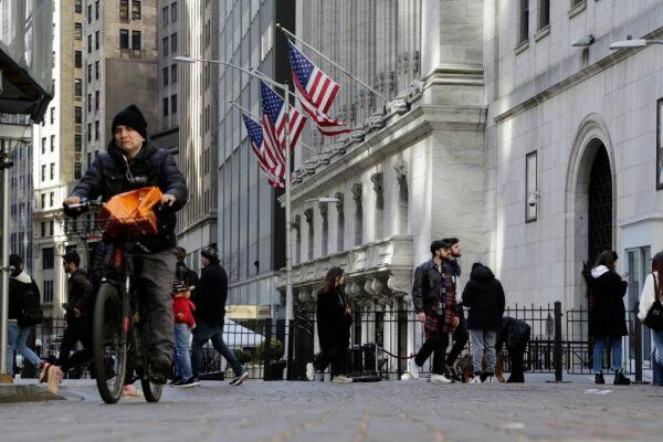 People pass the front of the New York Stock Exchange on March 21, 2023. (Peter Morgan/AP Photo)