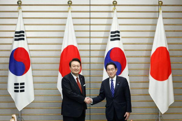 South Korean President Yoon Suk-yeol (L) and Japanese Prime Minister Fumio Kishida shake hands ahead of a summit meeting at the prime minister's official residence in Tokyo, Japan, on March 16, 2023. (Kiyoshi Ota/Pool/Getty Images)