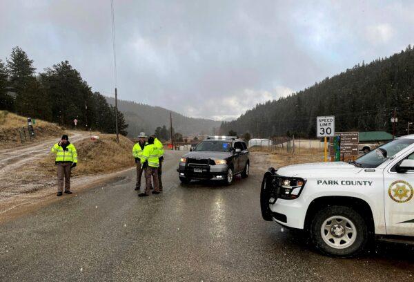 Sheriff deputies block a road in the town of Bailey, Colo., where authorities found an abandoned car that belonged to the suspect in a shooting of two administrators at a Denver high school on March 22, 2023. (Thomas Peipert/AP Photo)