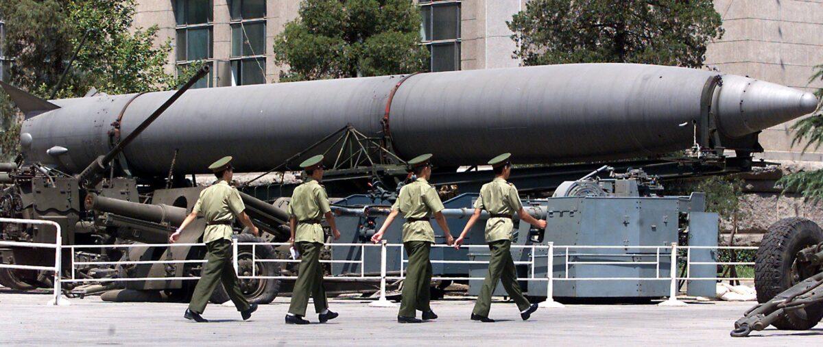 People's Liberation Army soldiers march past an old Chinese medium-range ballistic missile on display in front of Beijing's military museum on July 26, 1999. (Stephen Shaver/AFP via Getty Images)