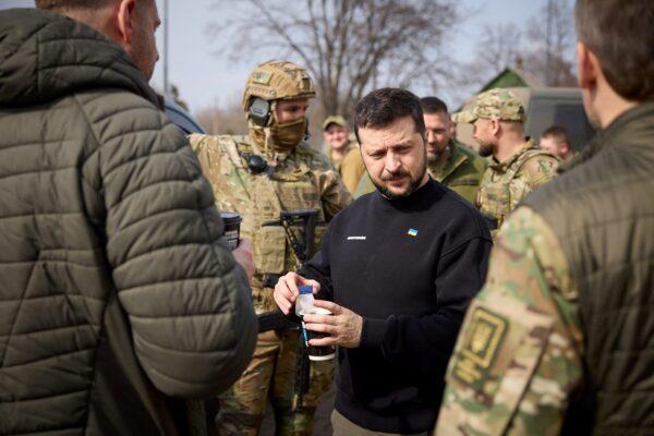 Ukraine's President Volodymyr Zelenskiyy holds a paper cup with tea at a petrol station, amid Russia's attack on Ukraine, as he visits Donetsk region, Ukraine, on March 22, 2023. (Ukrainian Presidential Press Service/Handout via Reuters)