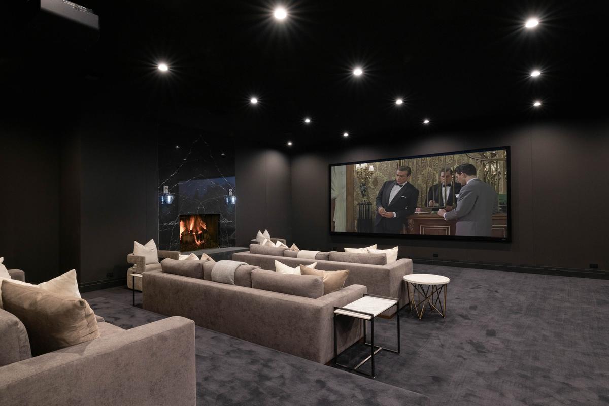 The in-home private theater allows friends and family to gather to watch movies or sports on the 136-inch screen, relaxing on comfy couches next to a crackling fireplace. (Courtesy of Tyler Hogan and TopTenRealEstateDeals.com)