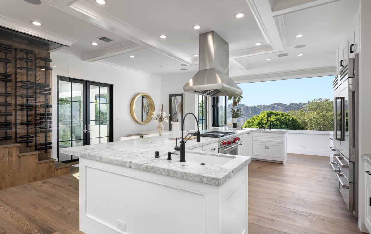 The kitchen is an ideal environment to create snacks, family meals, or formal dinners, with ample counter space and a glass wall that opens to bring the outside in. (Courtesy of Tyler Hogan and TopTenRealEstateDeals.com)