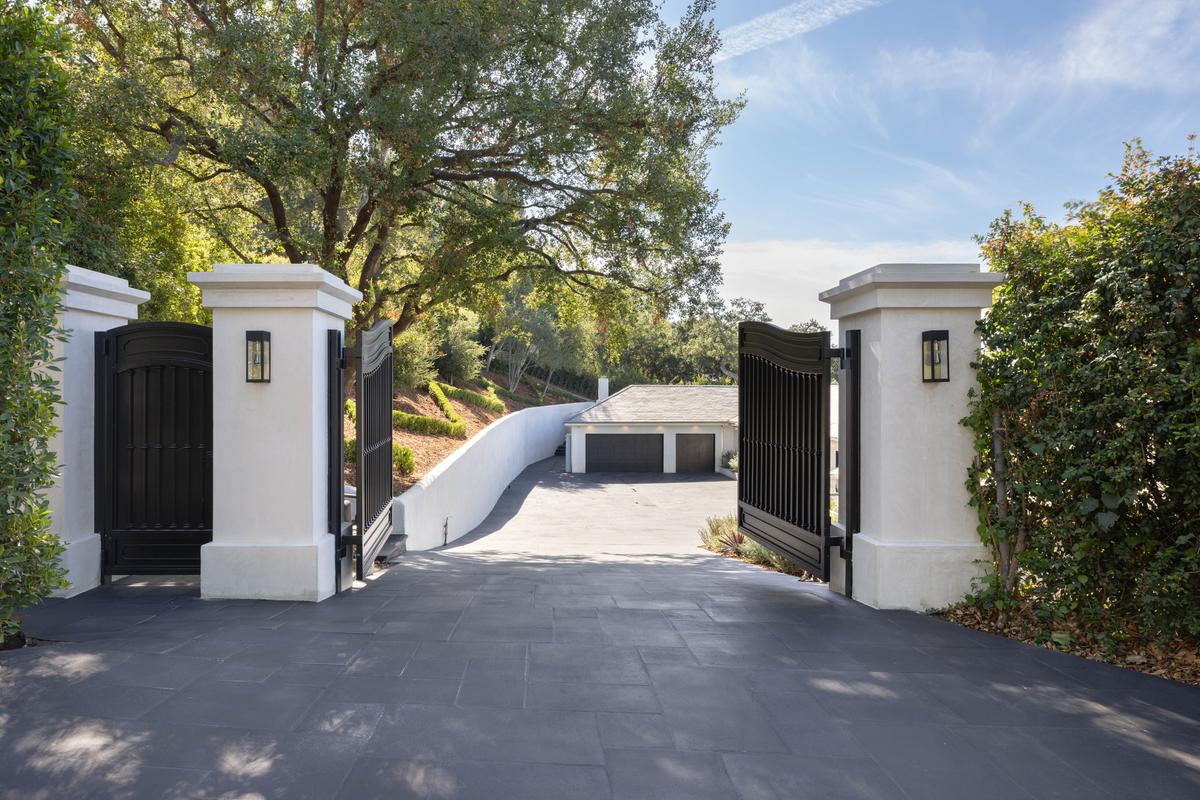 In addition to the community’s gated access, the homeowner’s privacy is ensured by formidable walls and massive gates. The garage has ample room for several vehicles. (Courtesy of Tyler Hogan and TopTenRealEstateDeals.com)