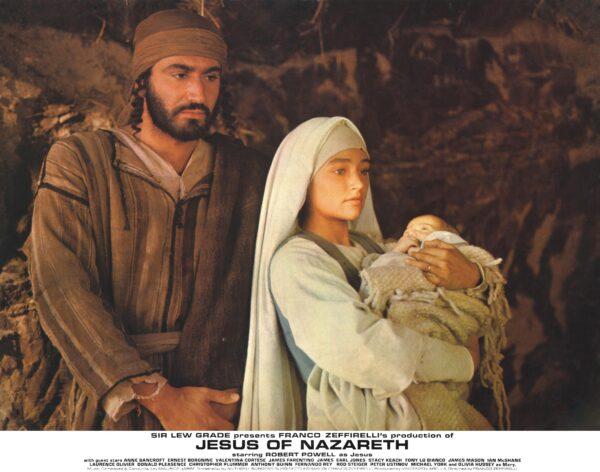 Joseph (Yorgo Voyagis) and Mary (Olivia Hussey) greet visitors who come to see the newborn Jesus. (Movie StillsDB)