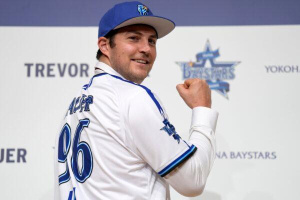 Trevor Bauer with his new uniform and cap of Yokohama DeNA BayStars poses for photographers during a photo session of the news conference in Yokohama, near Tokyo, on March 24, 2023. (Eugene Hoshiko/AP Photo)