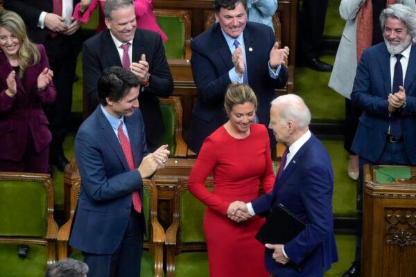 Canadian Prime Minister Justin Trudeau applauds as his wife, Sophie Gregoire Trudeau, shakes hands with U.S. President Joe Biden before Biden addresses the Canadian Parliament, in Ottawa on Mach 24, 2023. (Andrew Harnik/AFP via Getty Images)
