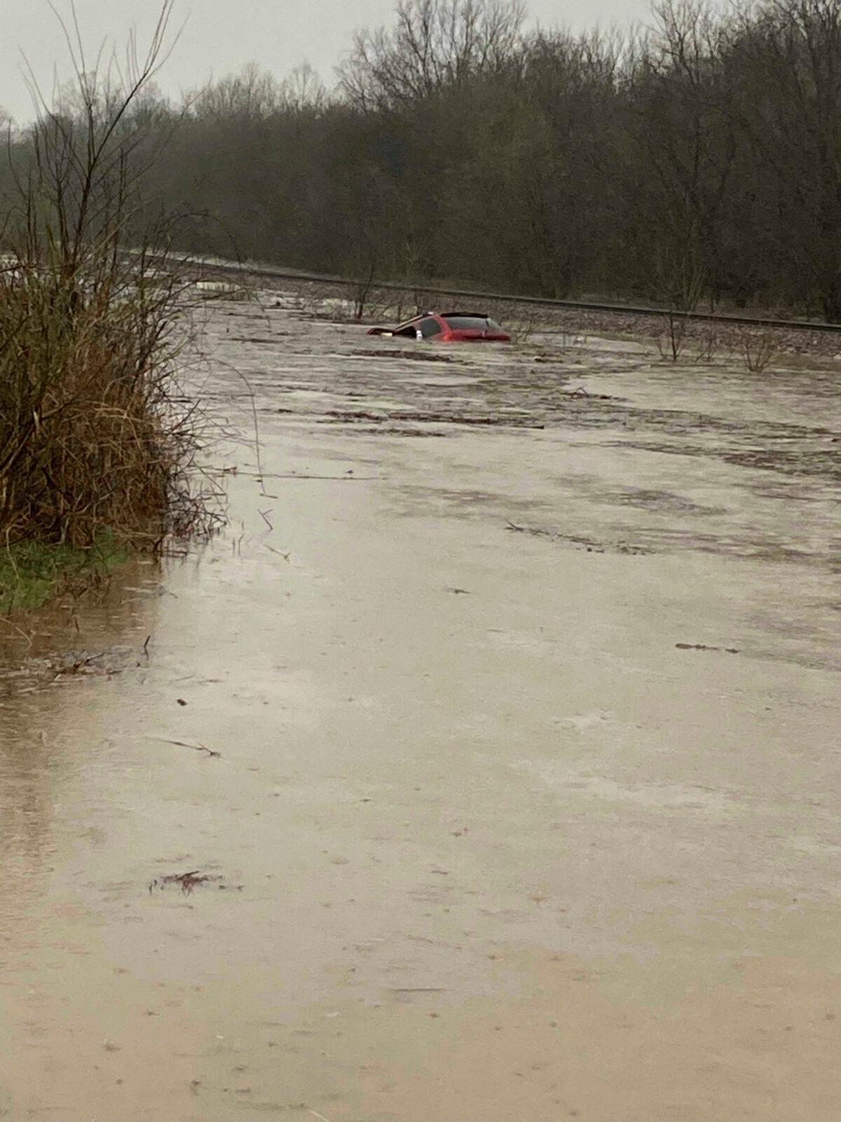A red SUV is submerged in floodwater on Old Ritchey Road in Granby, Mo., early on March 24, 2023. Hoyer rescued an elderly woman from the car. (Layton Hoyer via AP)