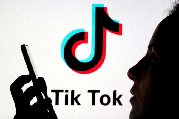 A person holds a smartphone as a Tik Tok logo is displayed behind in this picture illustration taken on Nov. 7, 2019. (Dado Ruvic/Reuters)