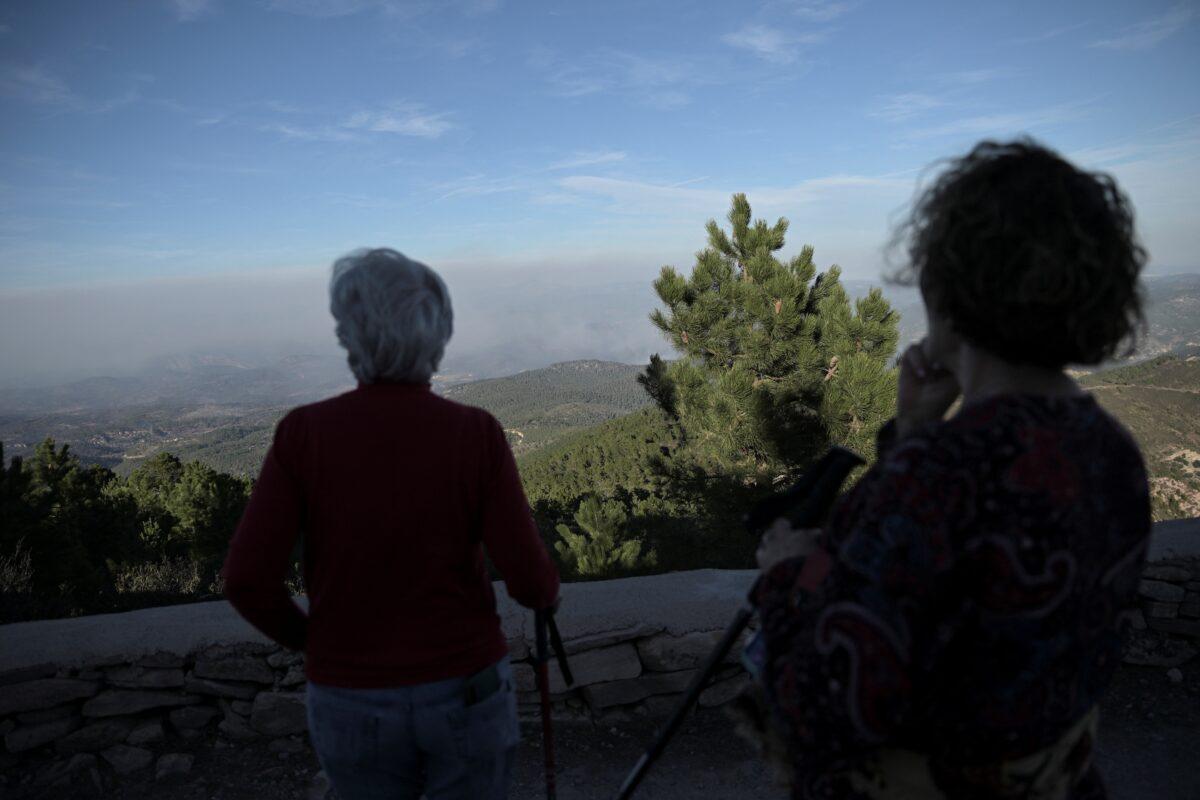 Neighbors in Monte Pina watch the wildfire on Barranco Maimona, Castellon, Spain, on March 25, 2023. (Lorena Sopena/Reuters)