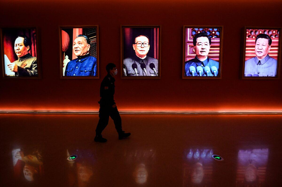 A man walks past portraits of (L to R) late CCP chairman Mao Zedong, former Chinese leaders Deng Xiaoping, Jiang Zemin, and Hu Jintao, and current president Xi Jinpingin in Yan'an, in China's northwest Shaanxi province, on Oct. 15, 2022, one day ahead of the 20th Communist Party Congress. (Jade Gao/AFP via Getty Images)
