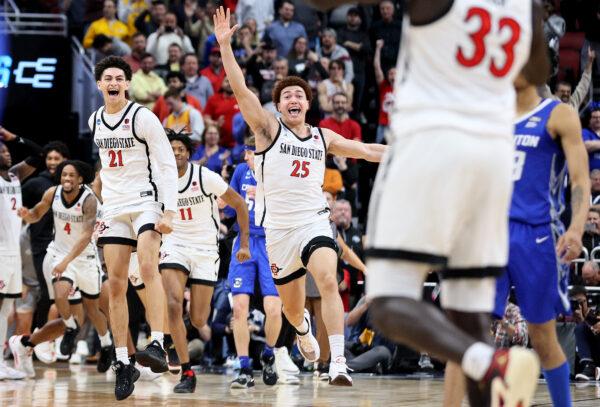 Miles Byrd (21), Demarshay Johnson Jr. (11) and Elijah Saunders (25) of the San Diego State Aztecs run to Aguek Arop (33) to celebrate defeating the Creighton Bluejays in the Elite Eight round of the NCAA Men's Basketball Tournament at KFC YUM! Center in Louisville, Ky., on March 26, 2023. (Andy Lyons/Getty Images)