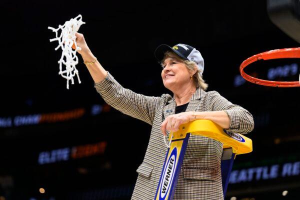 Iowa head coach Lisa Bluder holds up a net during a victory celebration after an Elite 8 college basketball game of the NCAA Tournament against Louisville in Seattle on March 26, 2023. (Caean Couto/AP Photo)