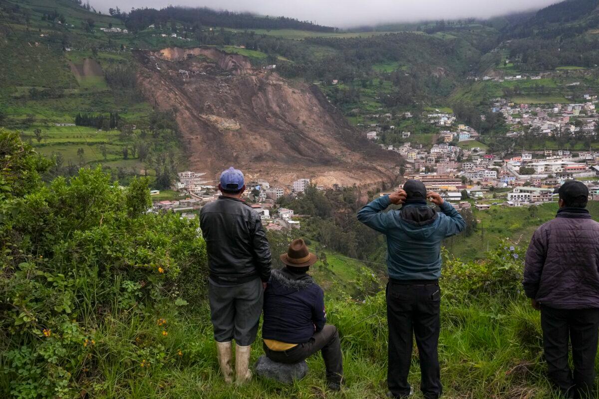 Residents look over the site of a landslide caused by heavy rain that buried dozens of homes in Alausi, Ecuador, on March 27, 2023. (Dolores Ochoa/AP Photo)