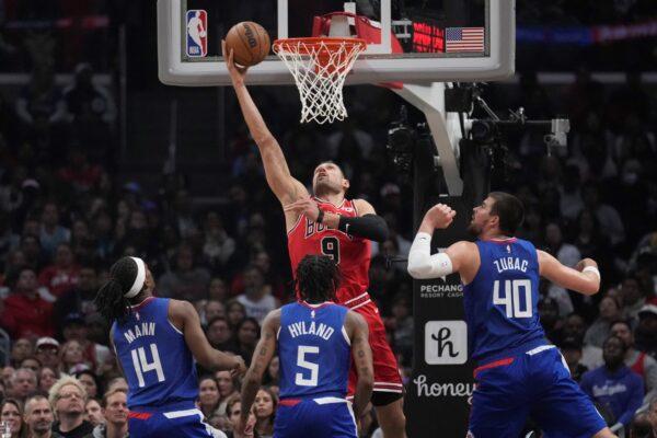 <br/>Chicago Bulls center Nikola Vucevic (9) scores over Los Angeles Clippers guard Terance Mann (14), guard Bones Hyland (5), and center Ivica Zubac (40) during the first half of an NBA basketball game in Los Angeles on March 27, 2023. (Marcio Jose Sanchez/AP Photo)