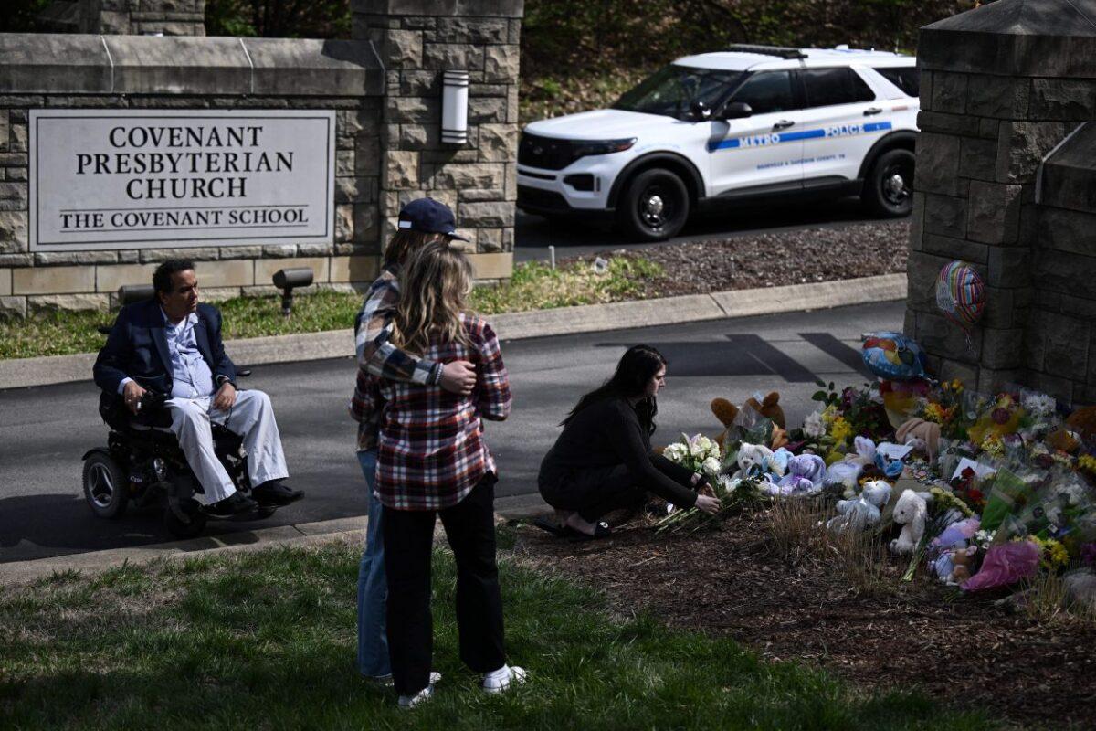 People pay their respects at a makeshift memorial for victims at the Covenant School building at the Covenant Presbyterian Church following a shooting, in Nashville, Tenn., on March 28, 2023. (Brendan SmialowskiAFP via Getty Images)