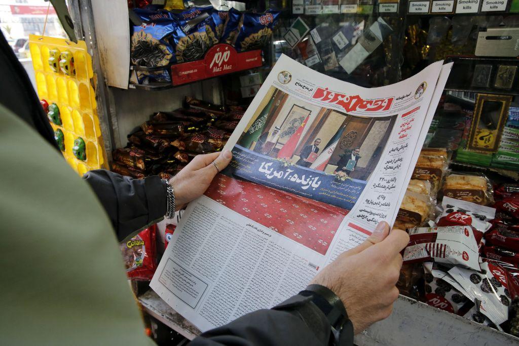 A shopkeeper in Tehran holds a local newspaper reporting on the China-brokered deal to restore ties between Iran and Saudi Arabia, on March 11, 2023. (Atta Kenare/AFP via Getty Images)