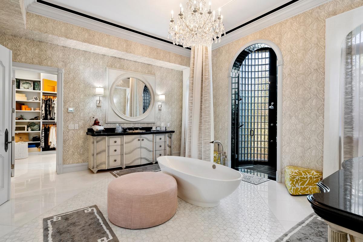 The master bath features a walk-in shower, a stand-alone tub, his and hers vanities, and a capacious adjacent walk-in closet. (Courtesy of James Northen / ONE Sotheby's International Realty)