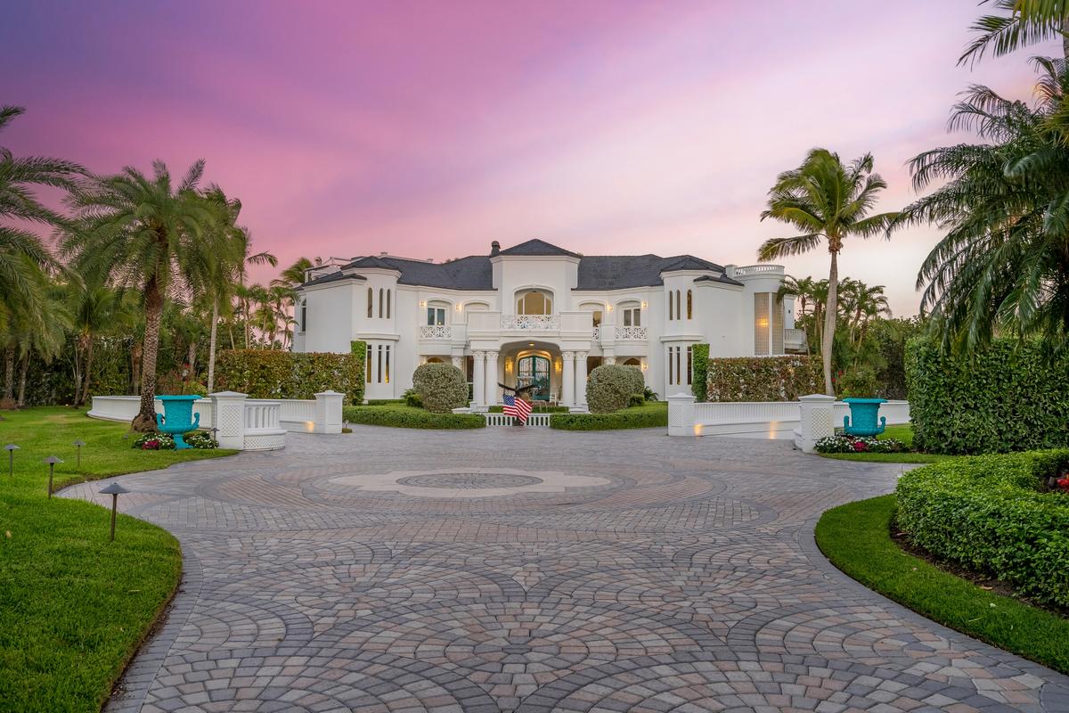The patterned driveway ensures a dramatic entrance to the main house, set amidst lush, manicured landscaping. (Courtesy of James Northen / ONE Sotheby's International Realty)