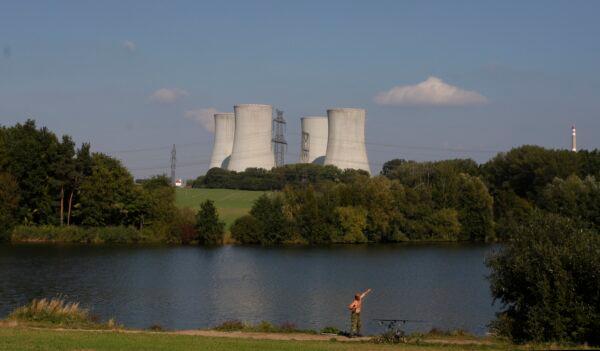 A man fishes with the towering Dukovany nuclear power plant in the background in Dukovany, Czech Republic, on Sept. 27, 2011. (Petr David Josek/AP Photo)