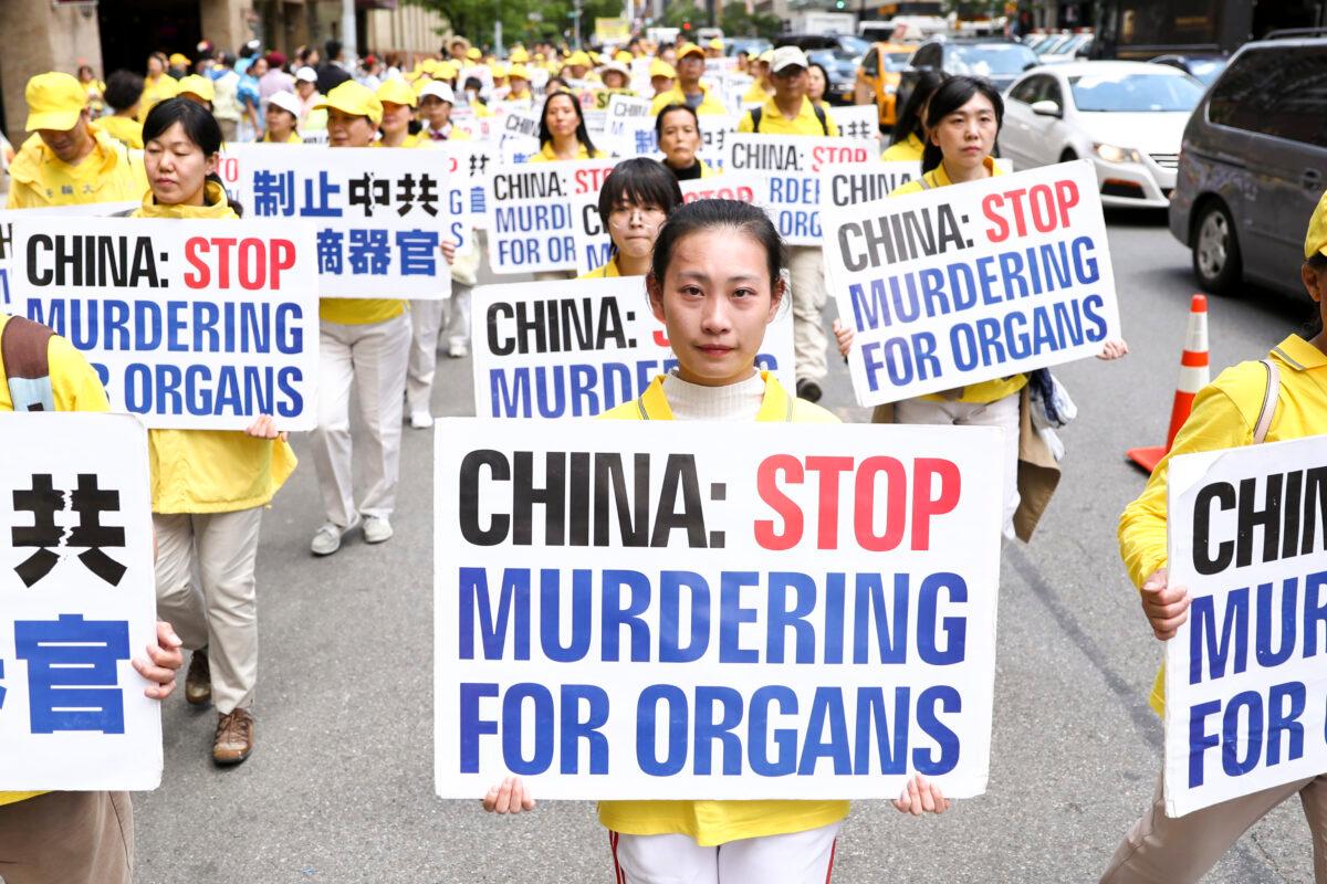 Falun Dafa practitioners hold placards in a parade to bring awareness to the Chinese regime's brutal practice of forced organ harvesting in China, in Manhattan, New York, on May 16, 2019. (Samira Bouaou/The Epoch Times)