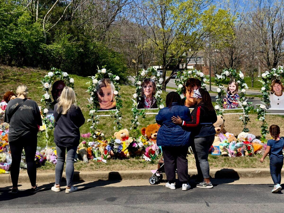 Onlookers visit the makeshift memorial for the six victims killed in the March 27, 2023, shooting at The Covenant School in Nashville. (Chase Smith/The Epoch Times)