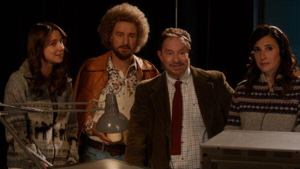 (L–R) Jenna (Lucy Freyer), Carl Nargle (Owen Wilson), station manager Tony (Stephen Root), and producer Katherine (Michaela Watkins) in "Paint." (IFC Films)