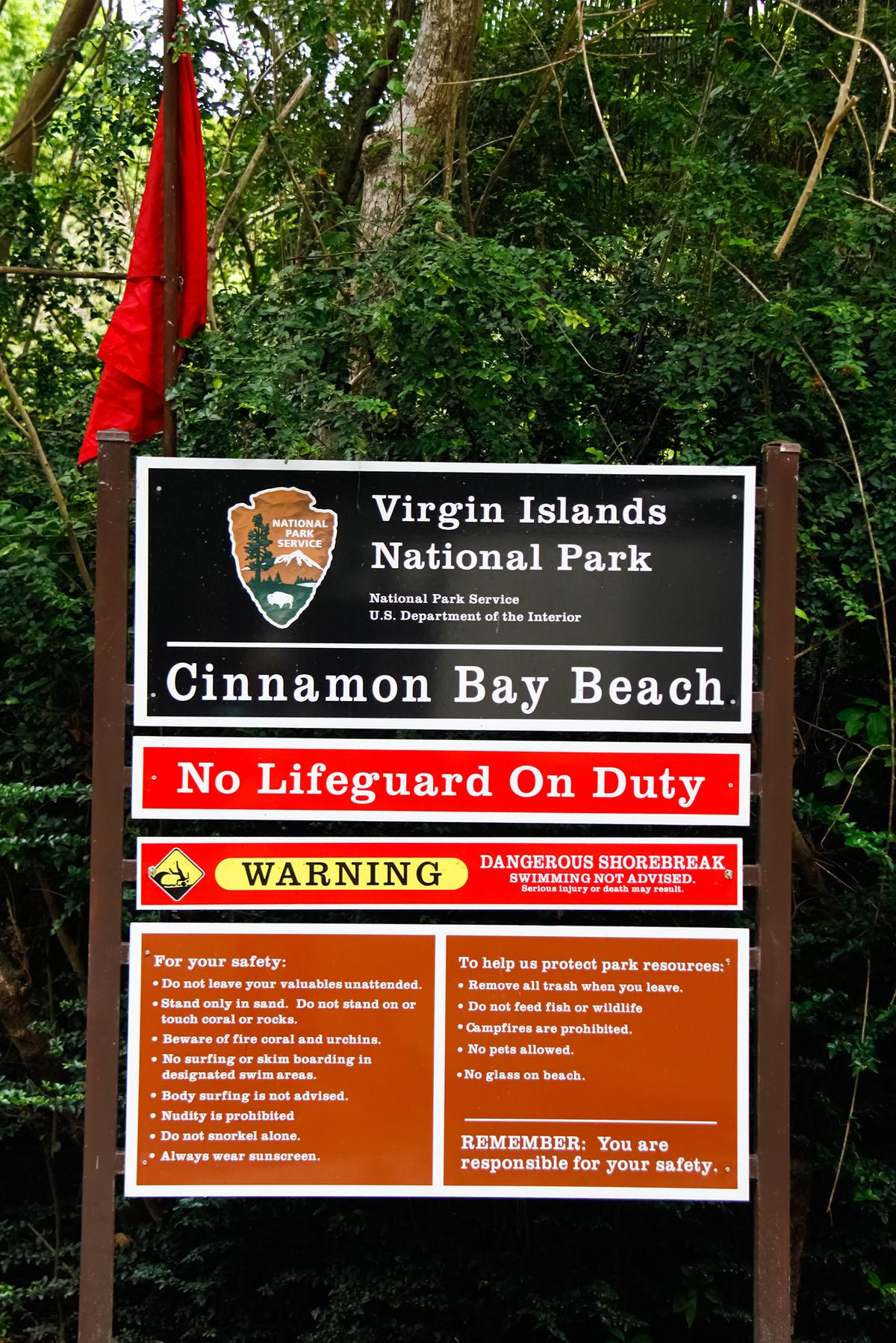 A sign greets visitors as they enter Cinnamon Bay Beach in the Virgin Islands National Park on the island of St. John. It also shows a Red Flag warning for high surf conditions.(Lawrence Weslowski Jr./Dreamstime/TNS)