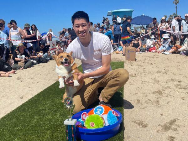 Jeff Wu and his corgi Bubbles win first place for the Corgi Beach Day fetch challenge in Huntington Beach, Calif., on April 1, 2023. (Carol Cassis/The Epoch Times)