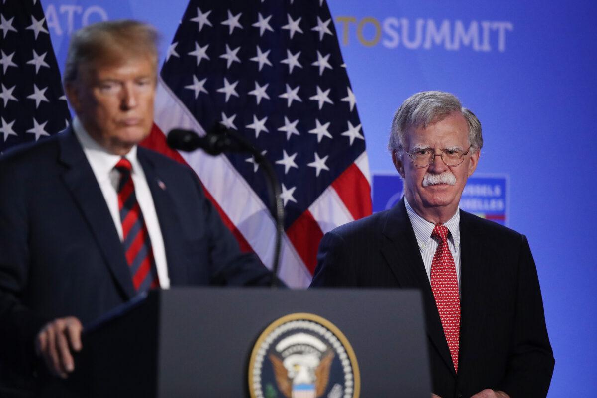 Then-U.S. President Donald Trump, flanked by then-National Security Adviser John Bolton, speaks to the media at a press conference on the second day of the 2018 NATO Summit in Brussels, Belgium, on July 12, 2018. (Sean Gallup/Getty Images)