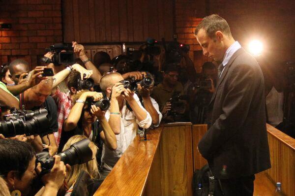 Photographers take photos of Olympic athlete Oscar Pistorius as he appears at a bail hearing for the shooting death of his girlfriend Reeva Steenkamp, in Pretoria, South Africa, on Feb 20, 2013. (Themba Hadebe/AP Photo)