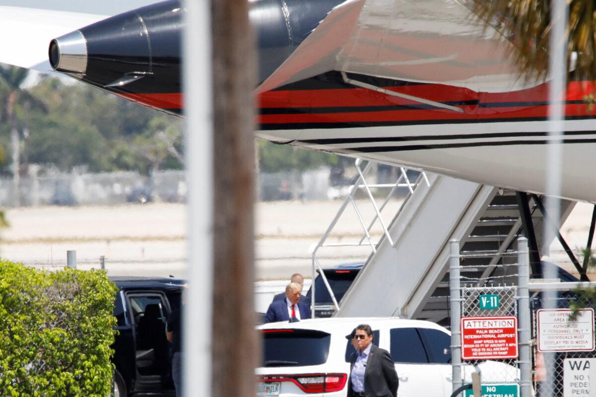Former President Donald Trump stands near his plane at the Palm Beach International Airport as he departs for New York, in West Palm Beach, Fla., on April 3, 2023. (Marco Bello/Reuters)