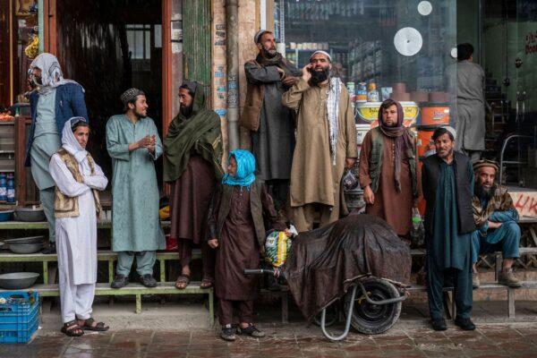 People shelter from the rain outside a shop in Kabul, Afghanistan, on March 22, 2023. (Wakil Kohsar/AFP via Getty Images)