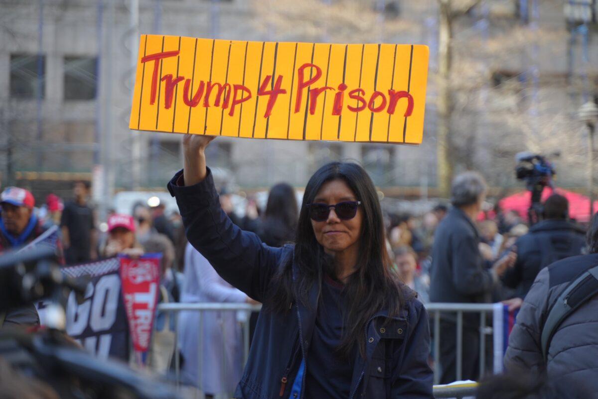A protester displays a "Trump 4 Prison" sign outside the New York courthouse where former President Donald Trump will be arraigned on April 4, 2023. (Chung I Ho/The Epoch Times)