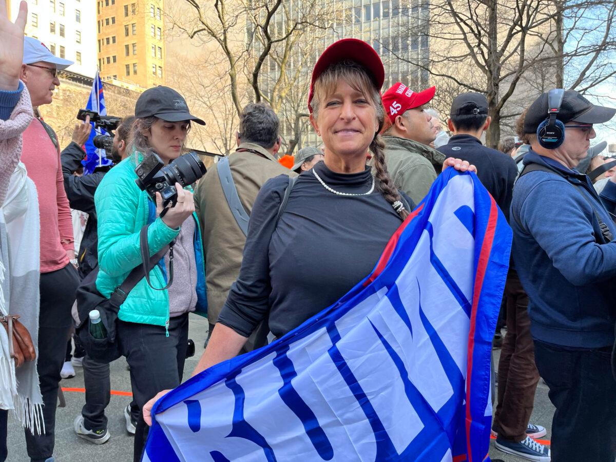 A protester carries a Trump flag in New York to protest the indictment of former President Donald Trump on April 4, 2023. (Eva Fu/The Epoch Times)