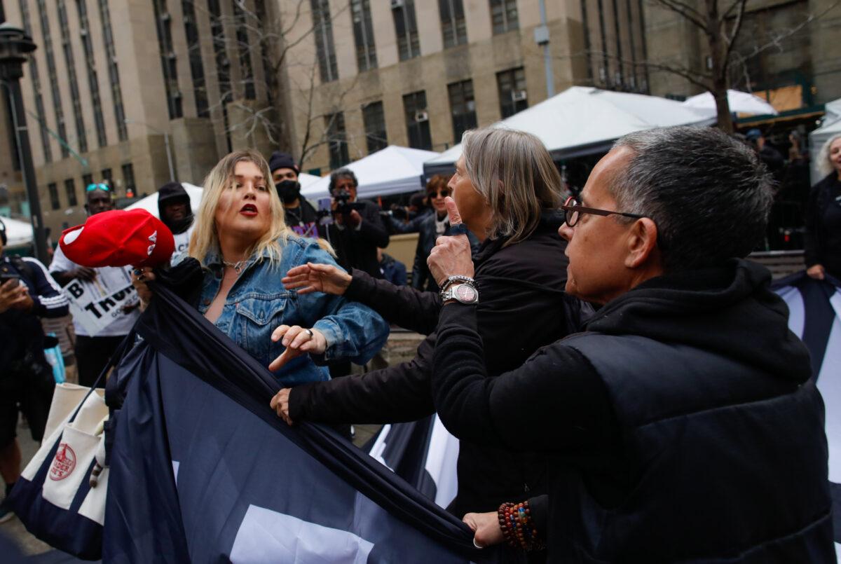 A Trump supporter (L) removes a banner from anti-Trump protesters outside the Manhattan Criminal Courthouse on April 04, 2023 in New York City. (Kena Betancur/Getty Images)