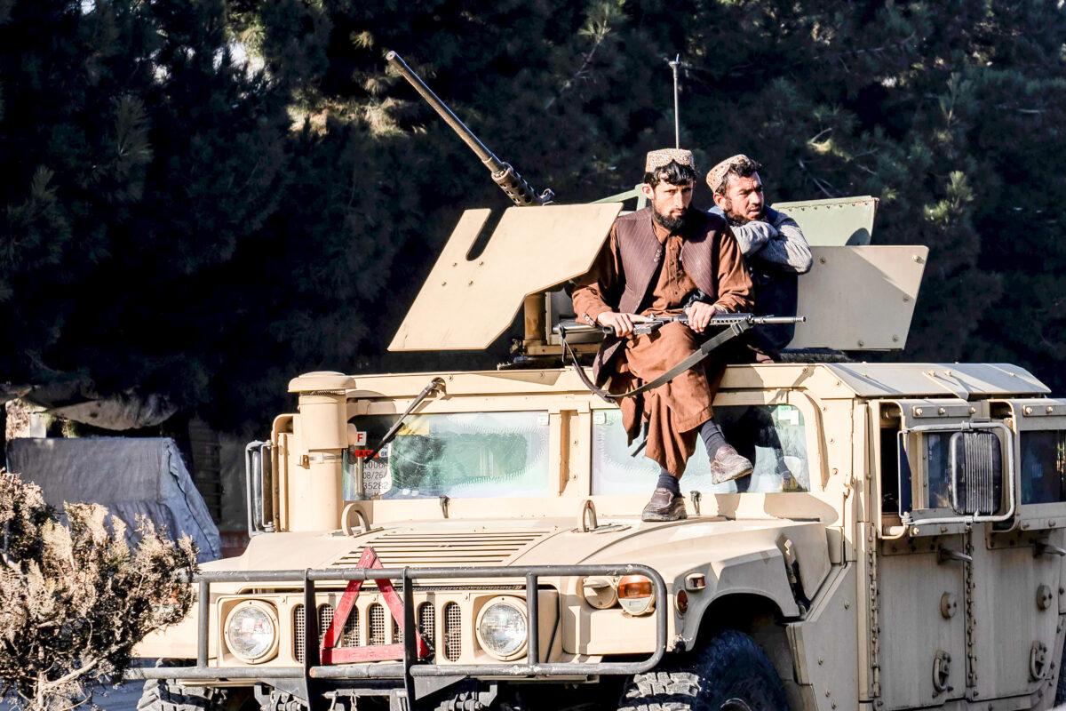Taliban fighters in a U.S. combat vehicle seized from the Afghan Army following its August 2021 collapse stand guard in Kabul, Afghanistan, on Jan. 1, 2023. (Ebrahim Noroozi/AP Photo)