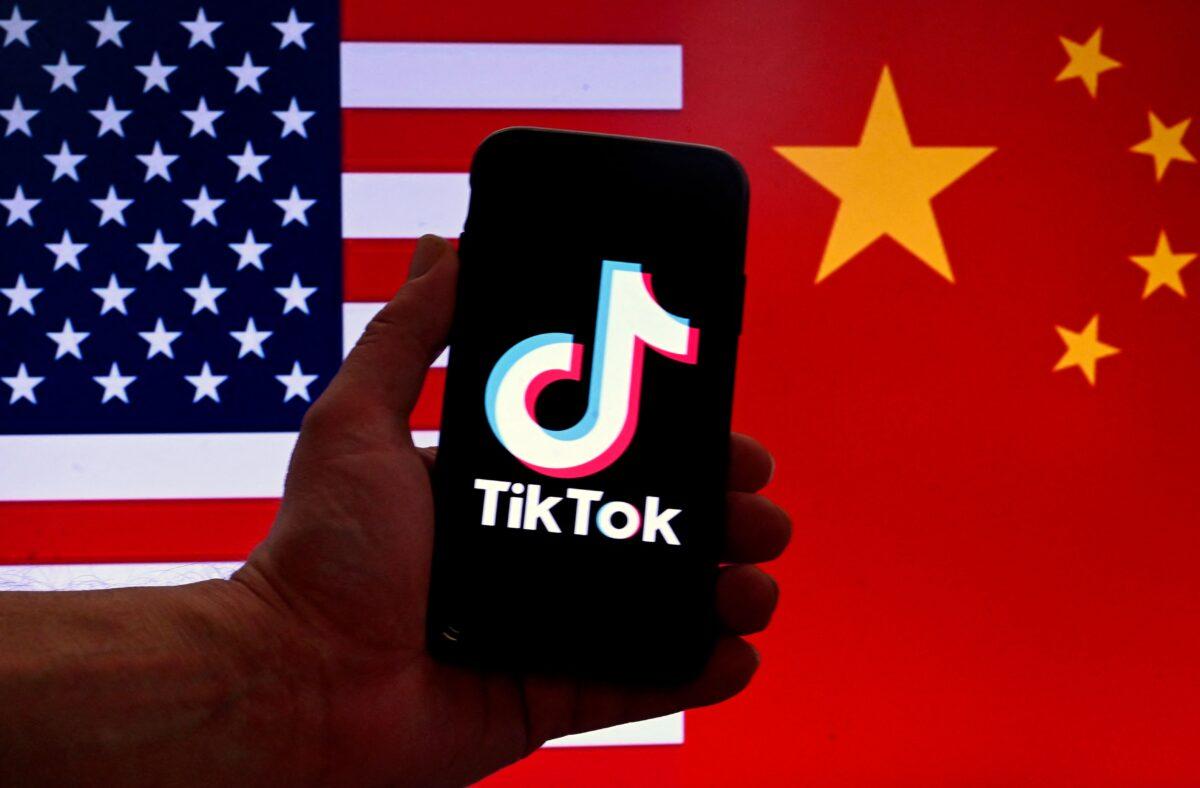 The social media application logo for TikTok is displayed on the screen of an iPhone in front of a U.S. flag and Chinese flag background in Washington on March 16, 2023. (Olivier Douliery/AFP via Getty Images)