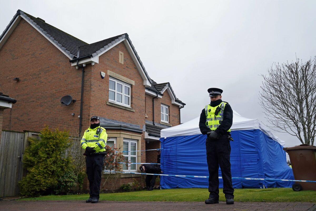 Officers from Police Scotland stand beside police tape and a police tent outside the home of former SNP chief executive Peter Murrell, in Uddingston, Glasgow, on April 5, 2023. (Andrew Milligan/PA Media)