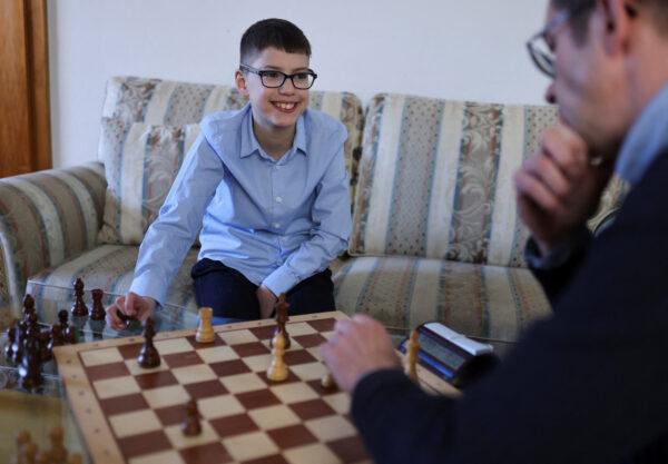Chess prodigy Hussain Besou, 11, of Syrian origin plays chess with Andreas Kuehler, his former coach of LSV Turm Lippstadt chess club, at his home in Lippstadt, Germany, on April 4, 2023. (Thilo Schmuelgen/Reuters)
