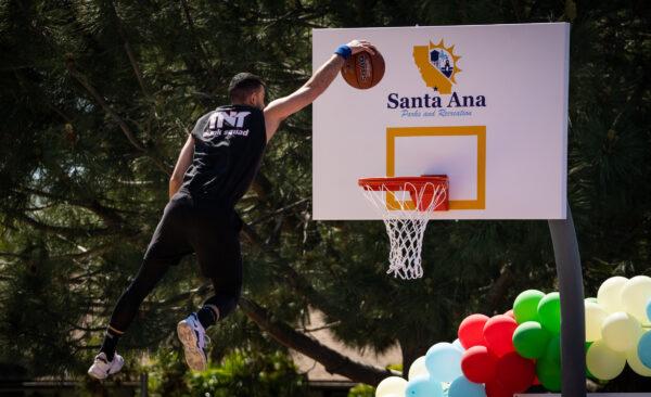 A man from the TNT Dunk Squad utilizes the newly donated basketball hoop of Portola Park in Santa Ana, Calif., on April 4, 2023. (John Fredricks/The Epoch Times)
