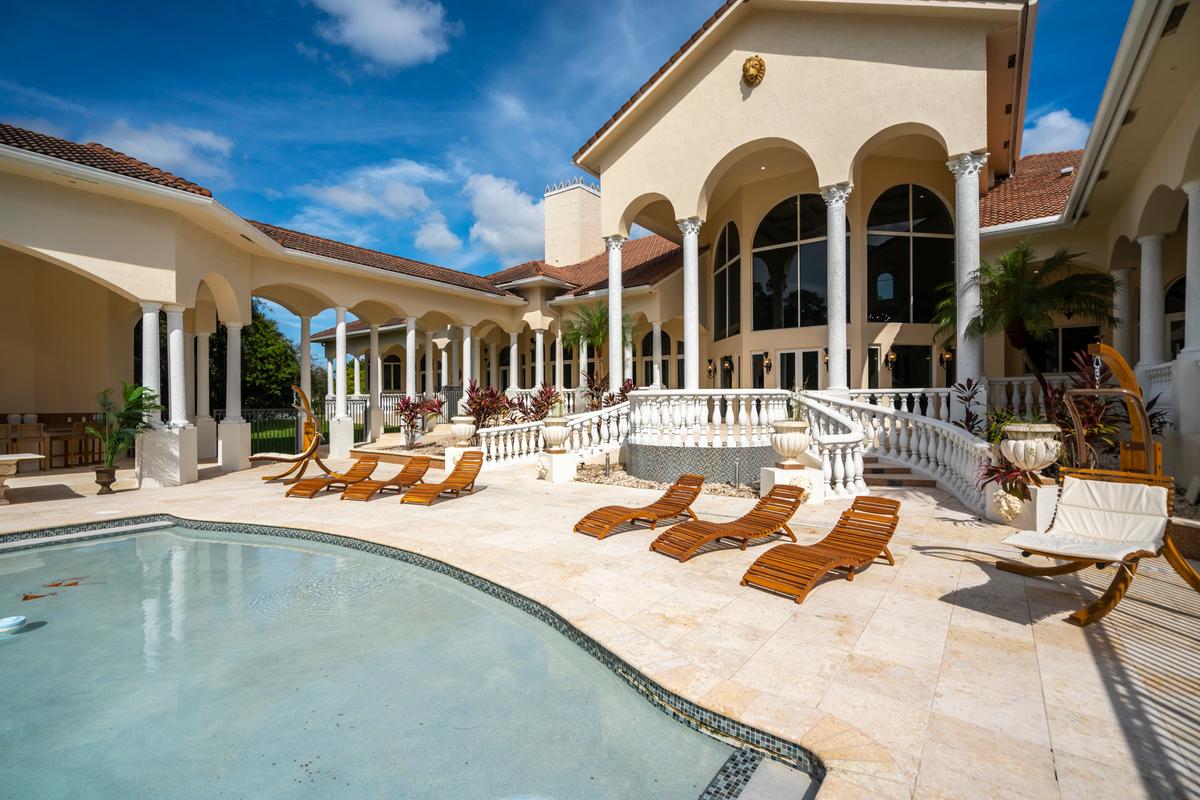 The home’s resort-sized pool area is ideal for entertaining, furnished with plenty of chaise lounges to accommodate guests. (Courtesy of The Carroll Group)